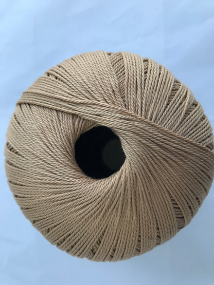 Ball of beige yarn on a light blue background
