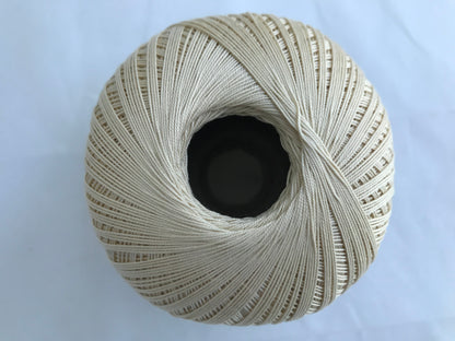 Spool of beige thread on a light blue background