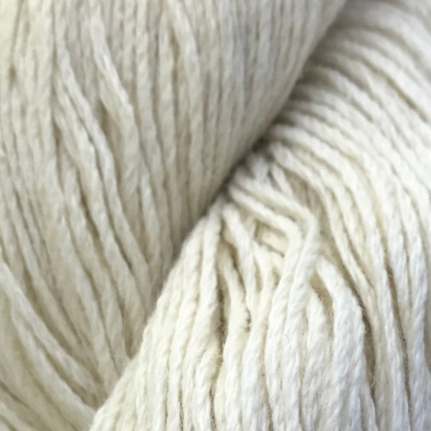 Close-up of two skeins of cream-colored yarn