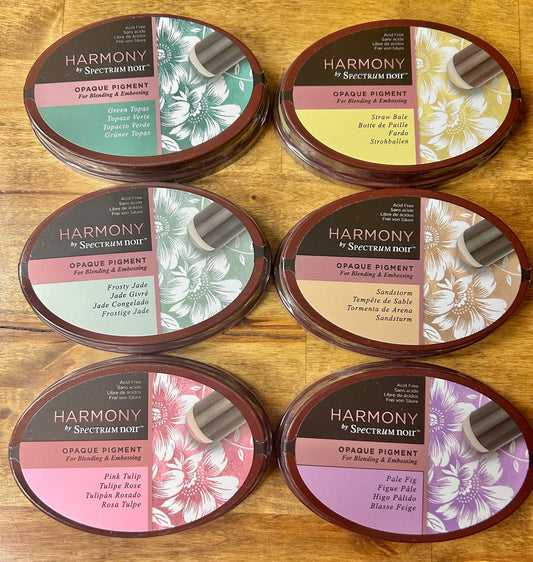 An image of a product box for Spectrum Noir archival pigment inks, featuring the colors Gold Plate, Silver Ingot, Ancient Bronze, and Pewter.