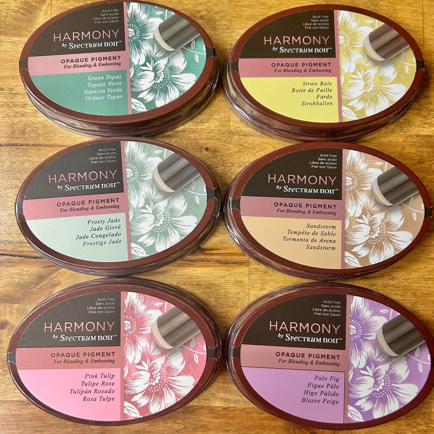 Harmony Opaque Pigment containers on a wooden surface