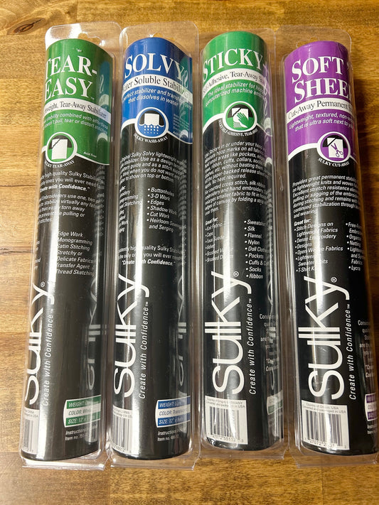 A high-quality image of four rolls of Sulky brand sewing and embroidery stabilizer products: Tear-Easy, Solvy water-soluble, Sticky self-adhesive tear-away, and Soft 'n Sheer cut-away.