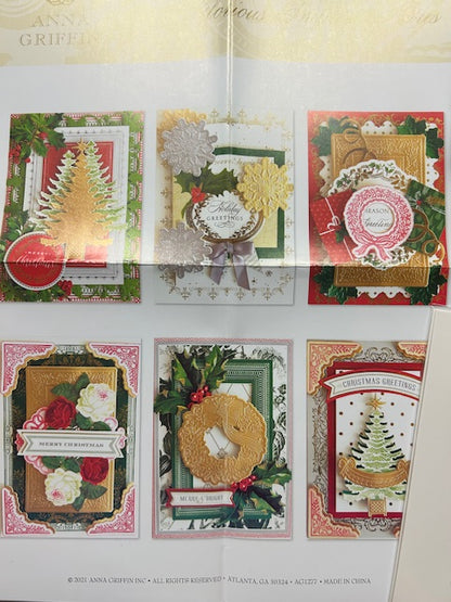 Six handmade holiday cards featuring intricate die-cut designs including Christmas trees, wreaths, and floral elements, created using Anna Griffin's 3D concentric frame dies.