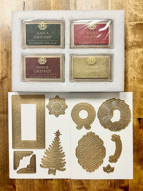 Anna Griffin Christmas Impression Dies and Ink Pads, including four ink pads (Fiorent, Fisslert, and two others) and several gold-colored Christmas-themed dies (wreath, tree, frame, holly).