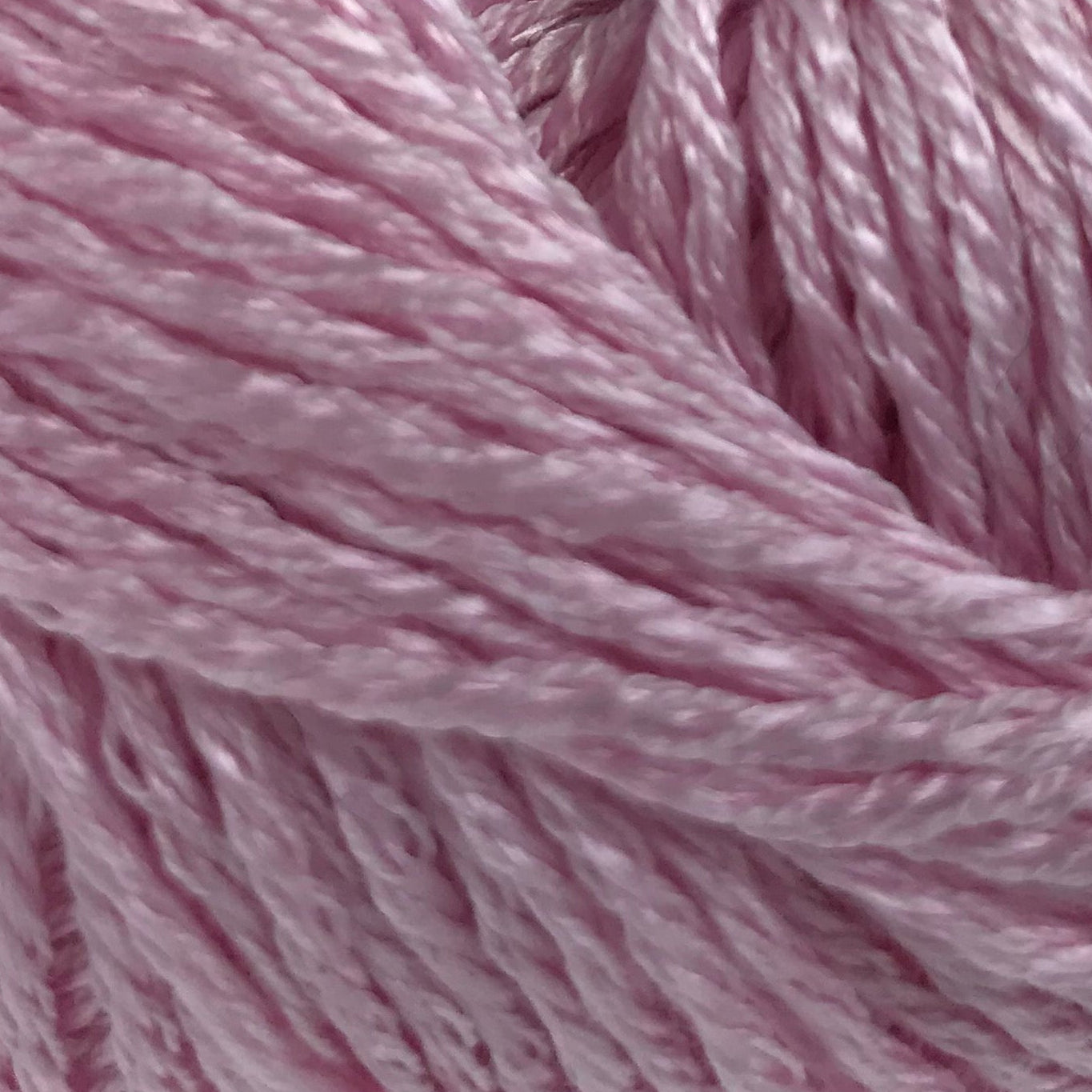 Pink yarn ball with a label on a white background