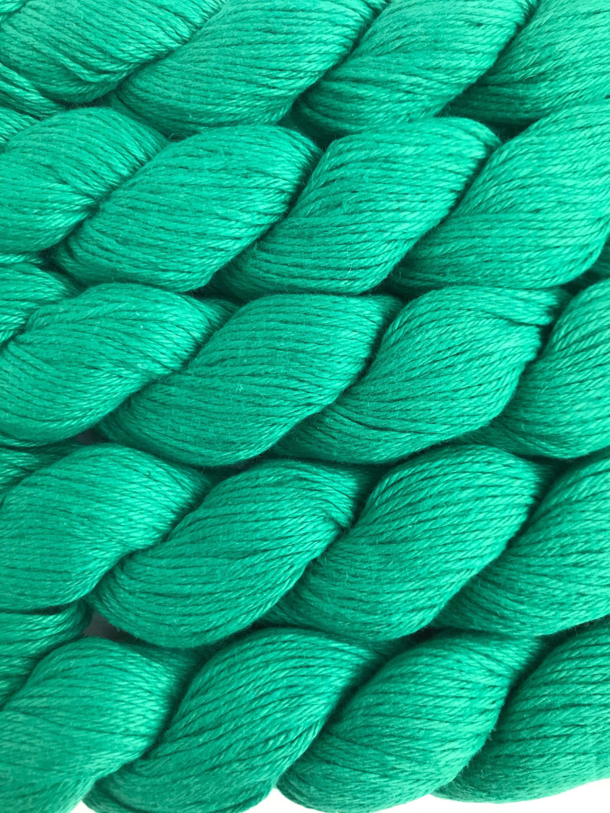 Close-up of green yarn skeins on a white background