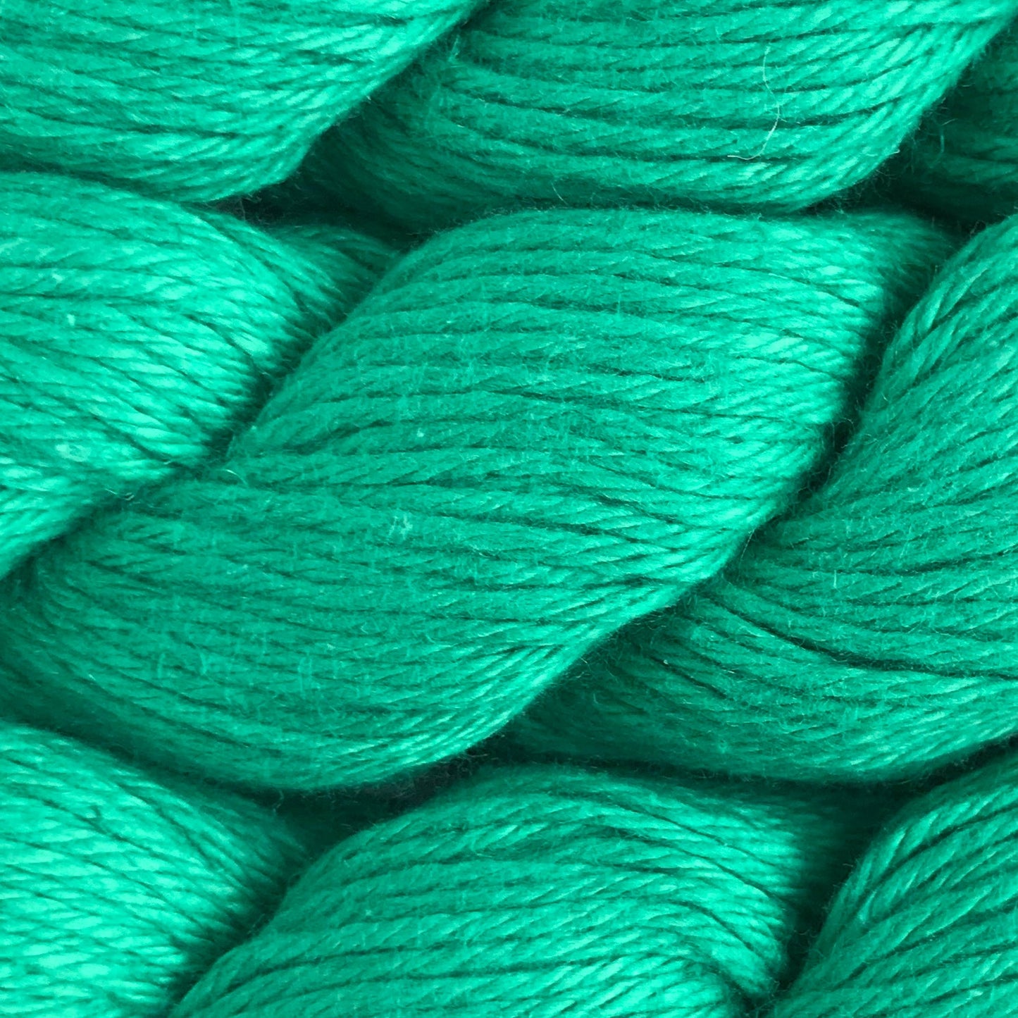 Close-up of green yarn skeins on a white background