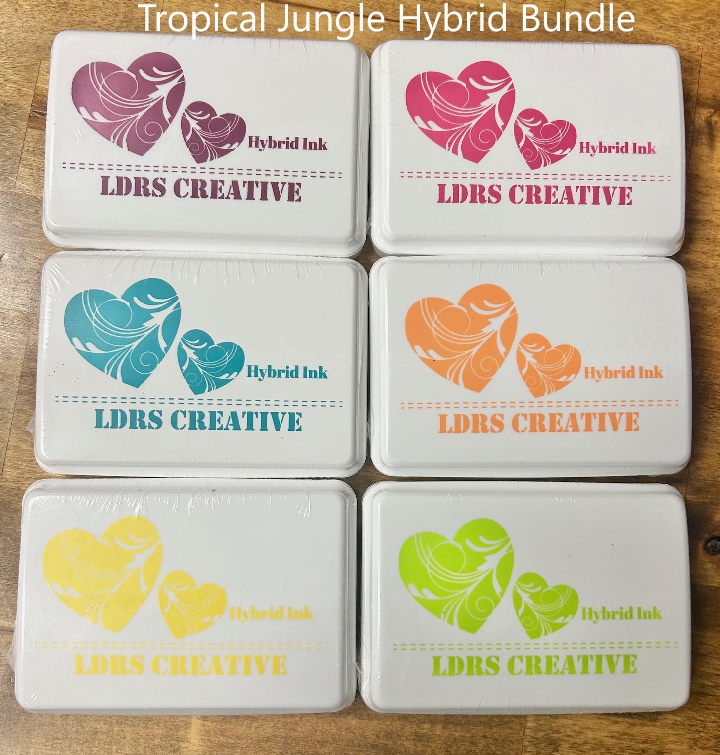 An alt text for the image is a high-quality description of six LDRS Creative Hybrid Ink pads in the "Tropical Jungle" color set. The square, white ink pads feature a raised felt surface.