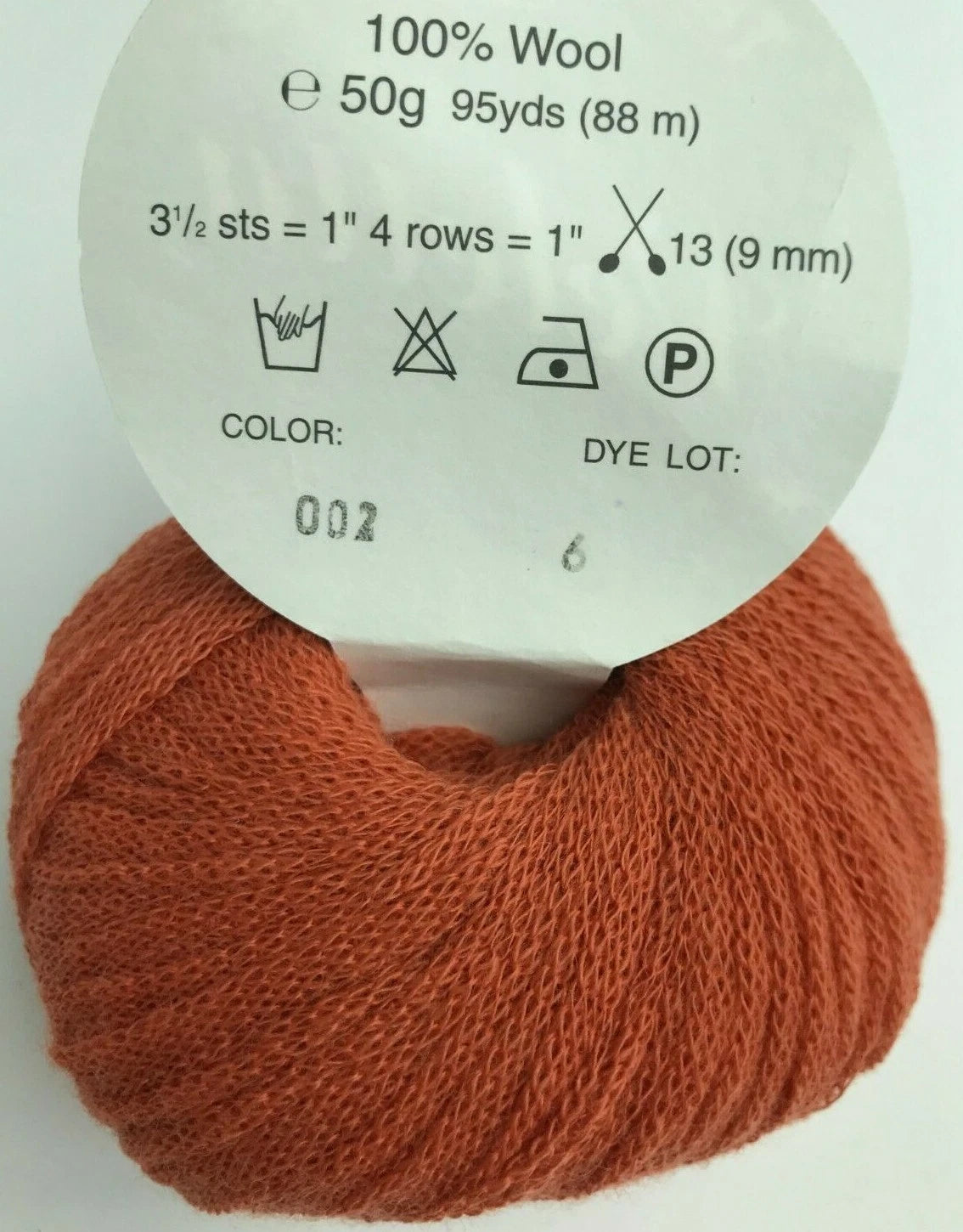 Ball of orange yarn with a label on a white background