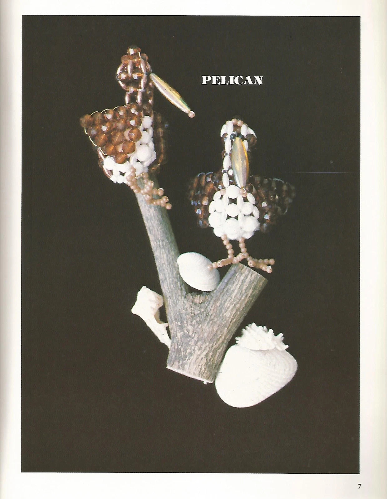 Jewelry set with pelican design on a branch against a black background