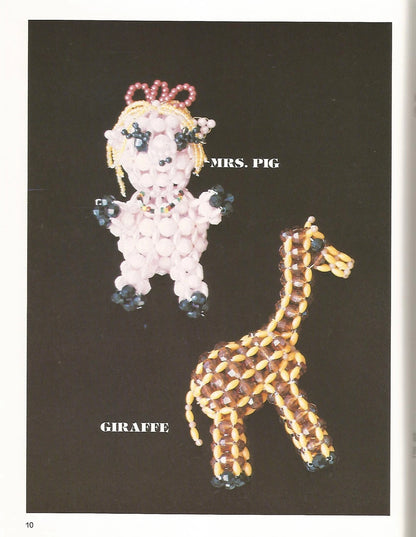 Beaded brooches shaped like a pig and a giraffe on a black background