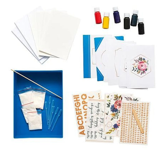 Crafting kit with paper, paint bottles, and templates on a white background
