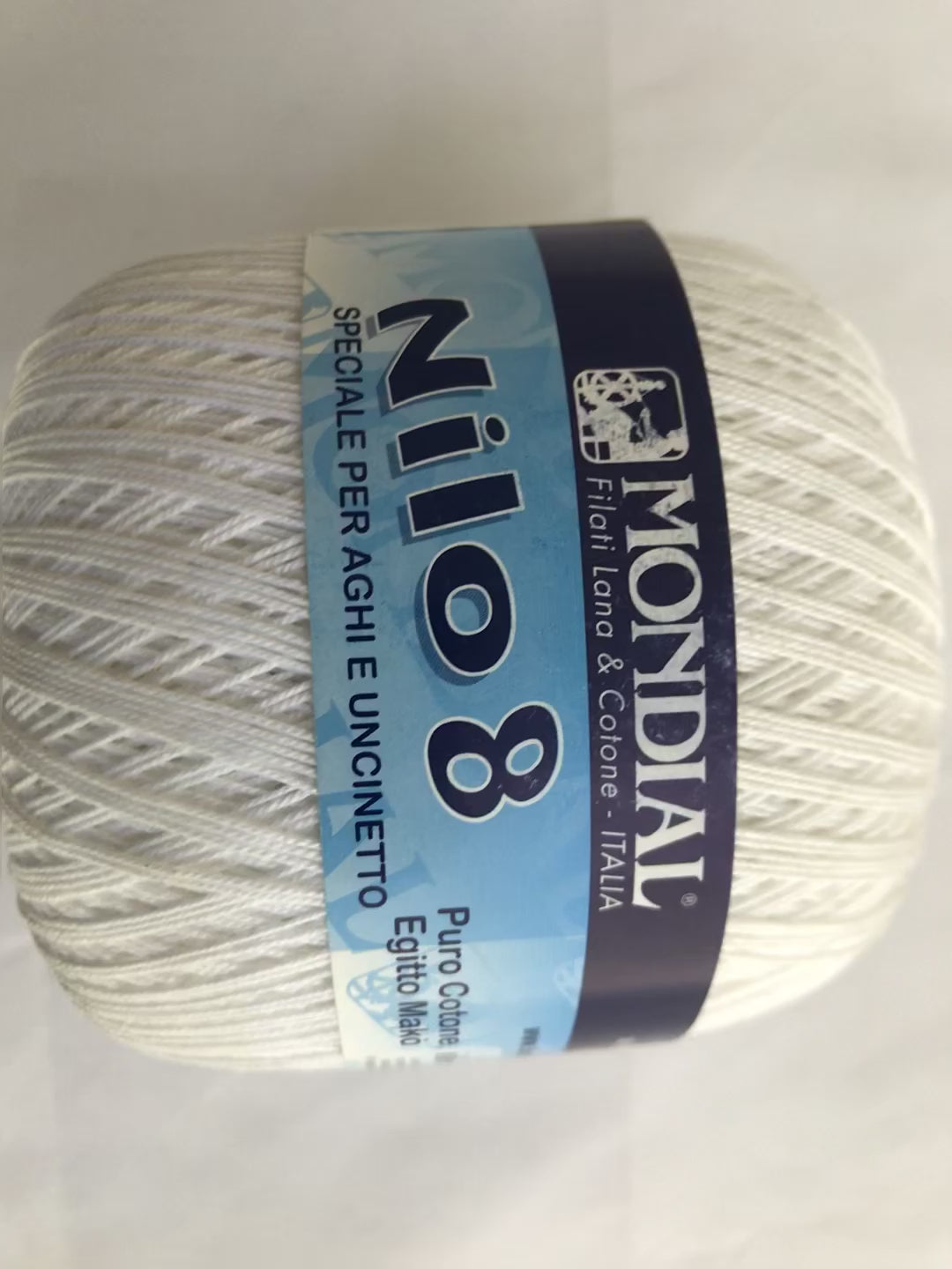 Ball of yarn with Mondial Nilo 8 label on a light gray background