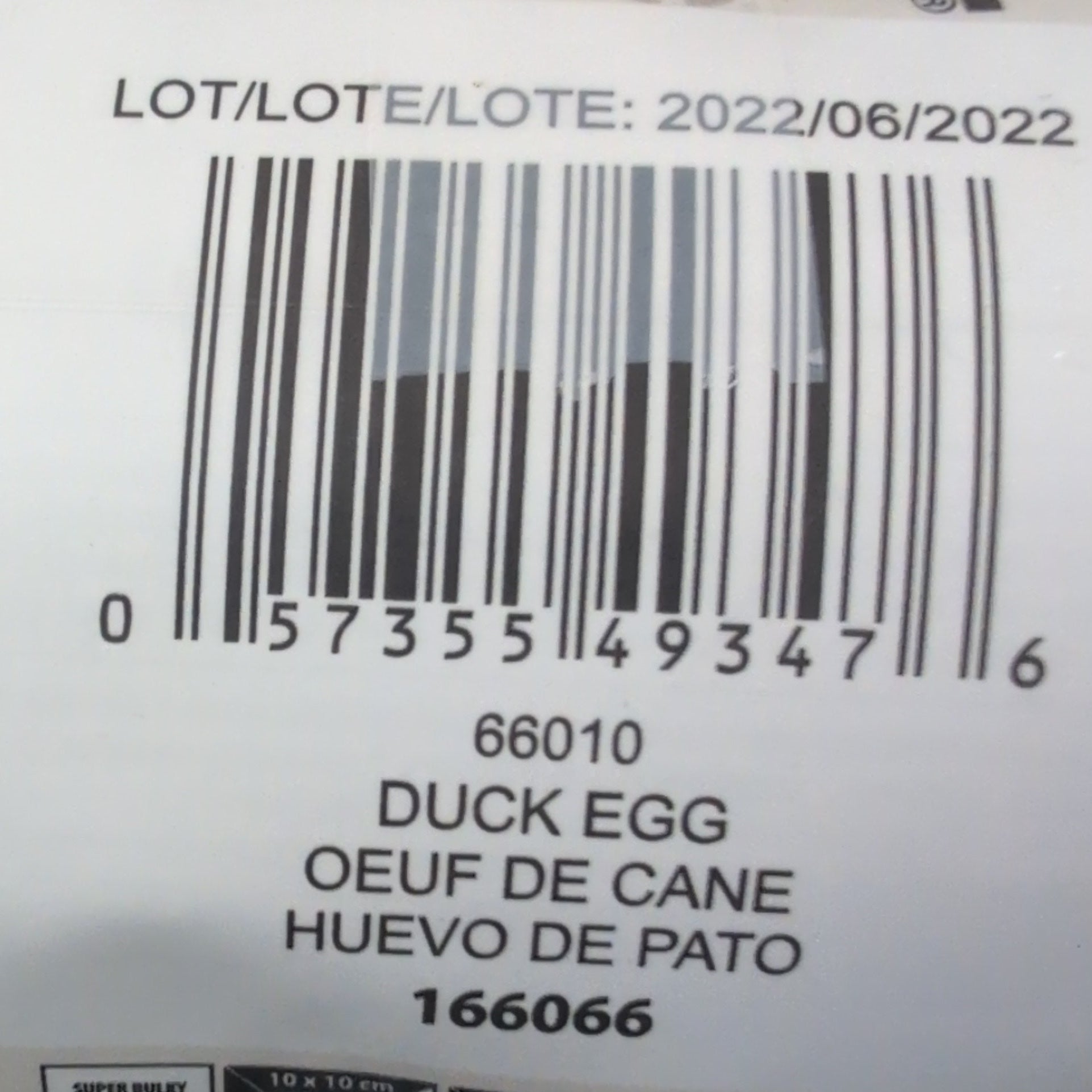 Close-up of a duck egg carton with a barcode and text on a wooden surface