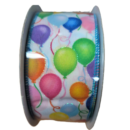 Spool of ribbon with colorful balloon design on a white background