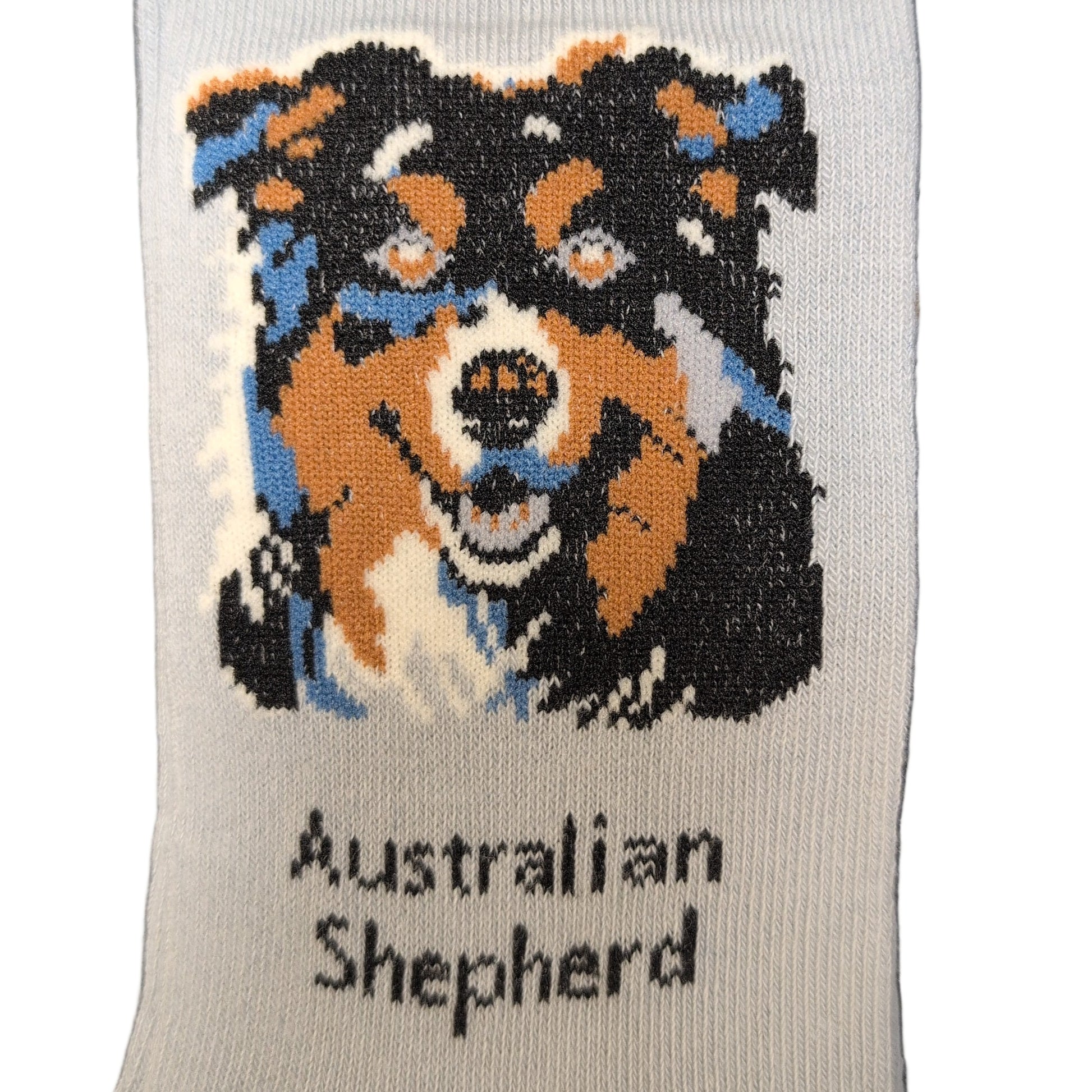 Sock with Australian Shepherd design and brand label on a dark surface