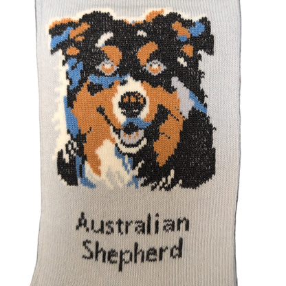 Sock with Australian Shepherd design and brand label on a dark surface