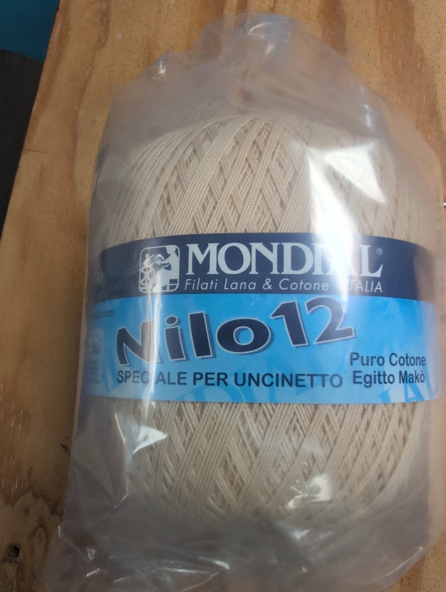 Ball of yarn with a Mondial label on a wooden surface