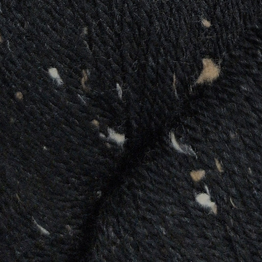 Close-up of dark fabric with small white and beige fibers