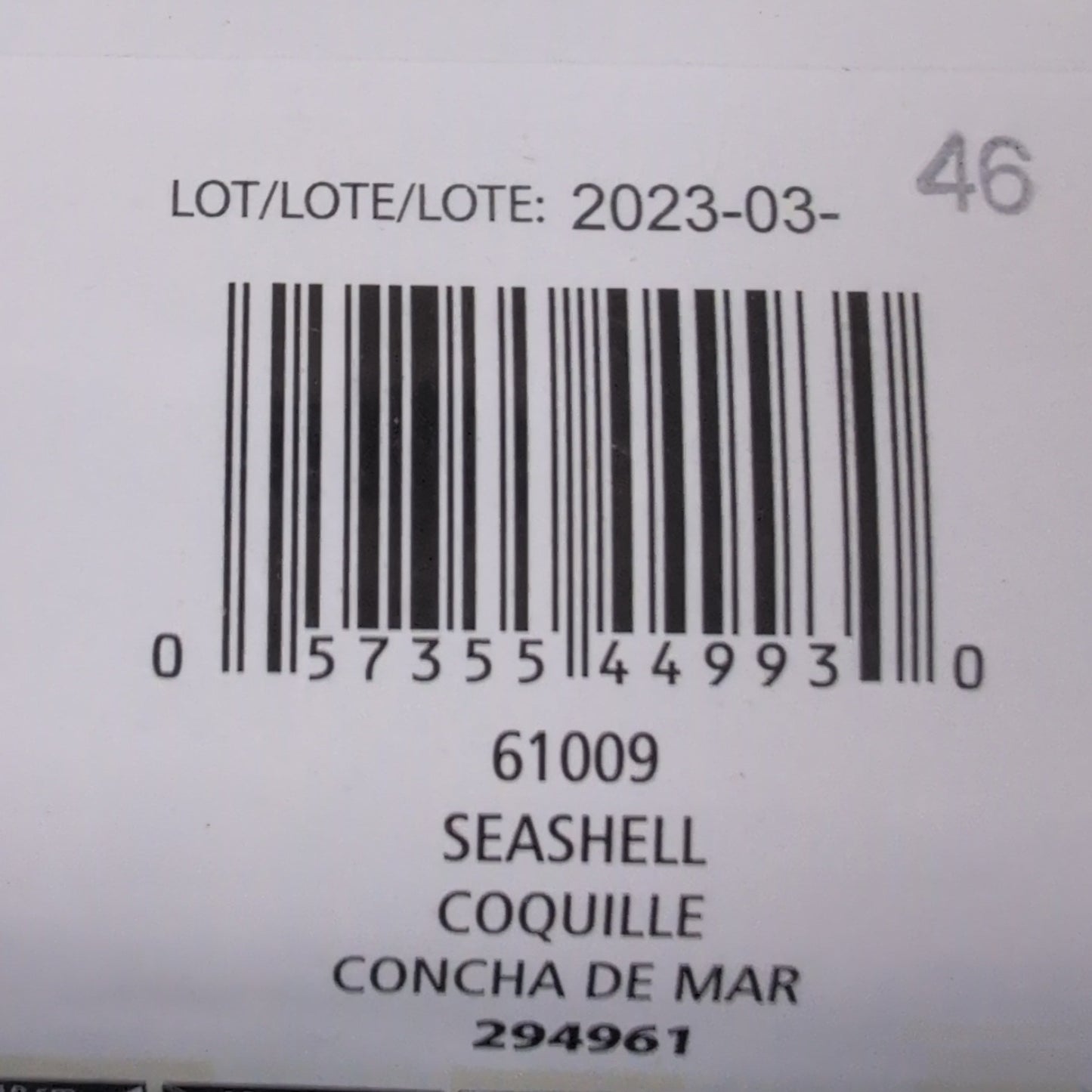 Close-up of a product label with barcodes and text on a textured surface