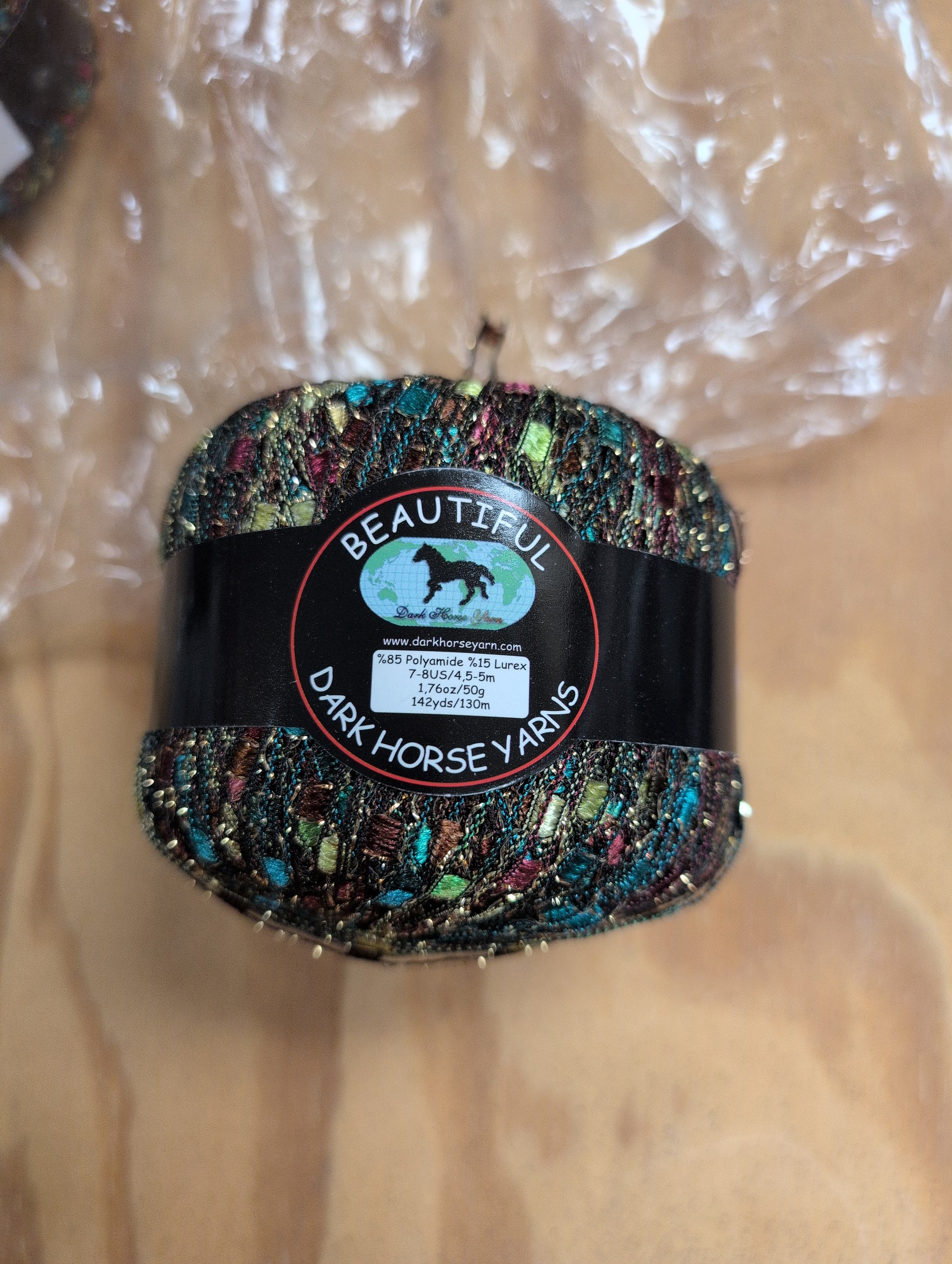 Colorful horse shoe with a label on a wooden surface
