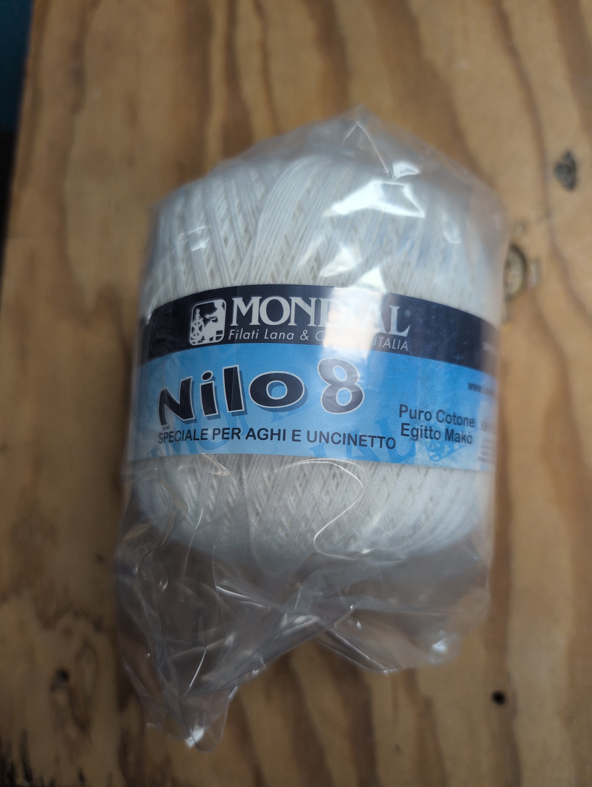 Ball of yarn with a 'Monaluna' label on a wooden surface
