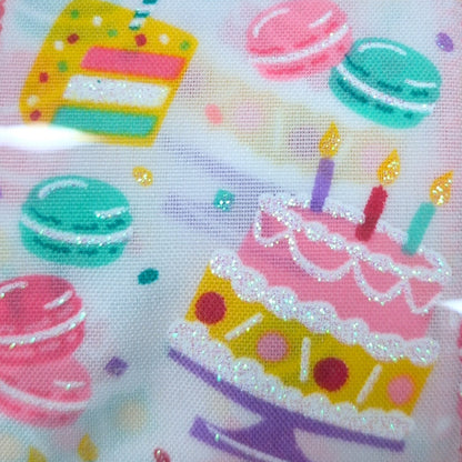 Fabric with colorful cake and macaron patterns on a light background