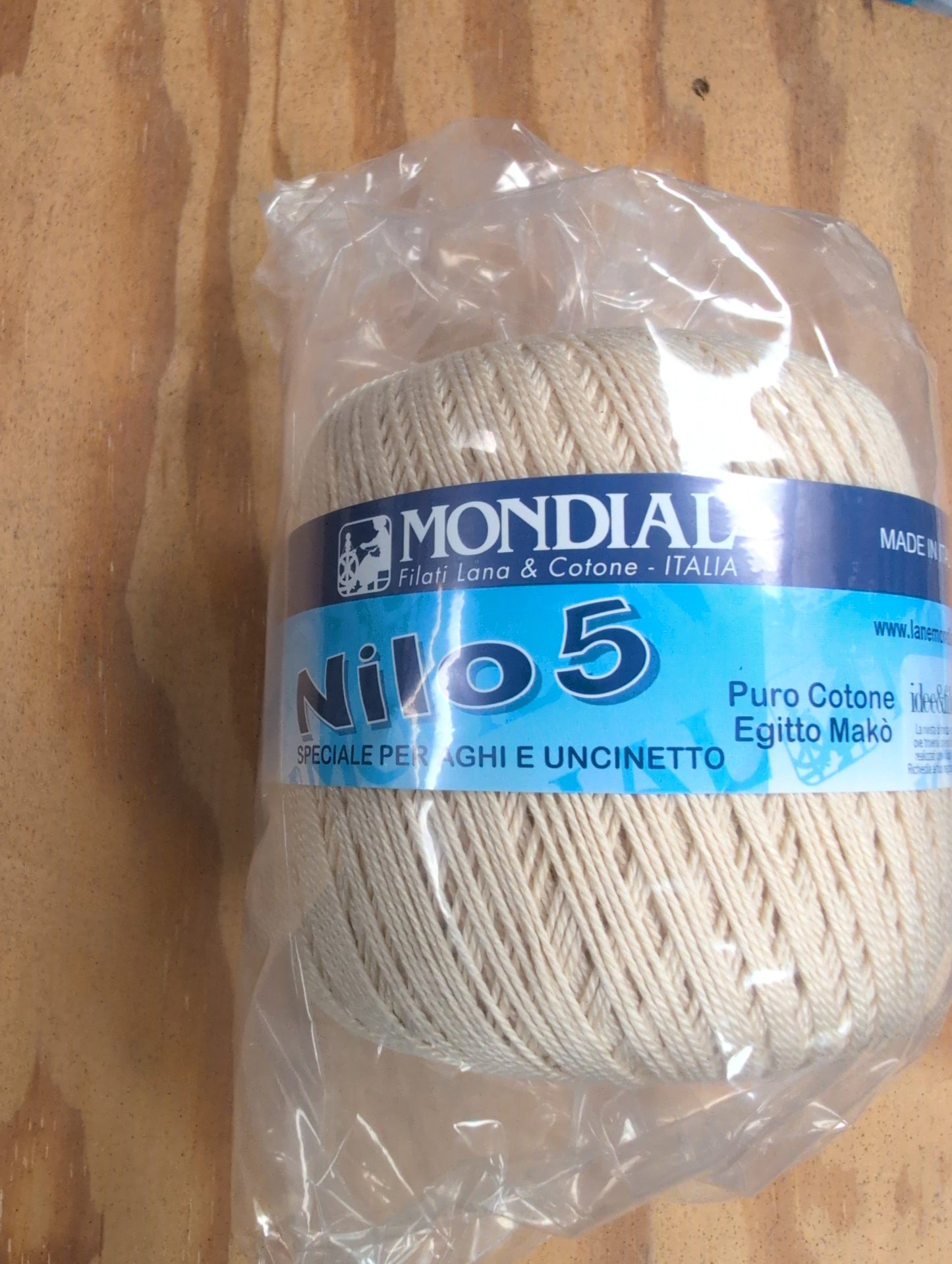 Ball of yarn with a Mondial label on a wooden surface
