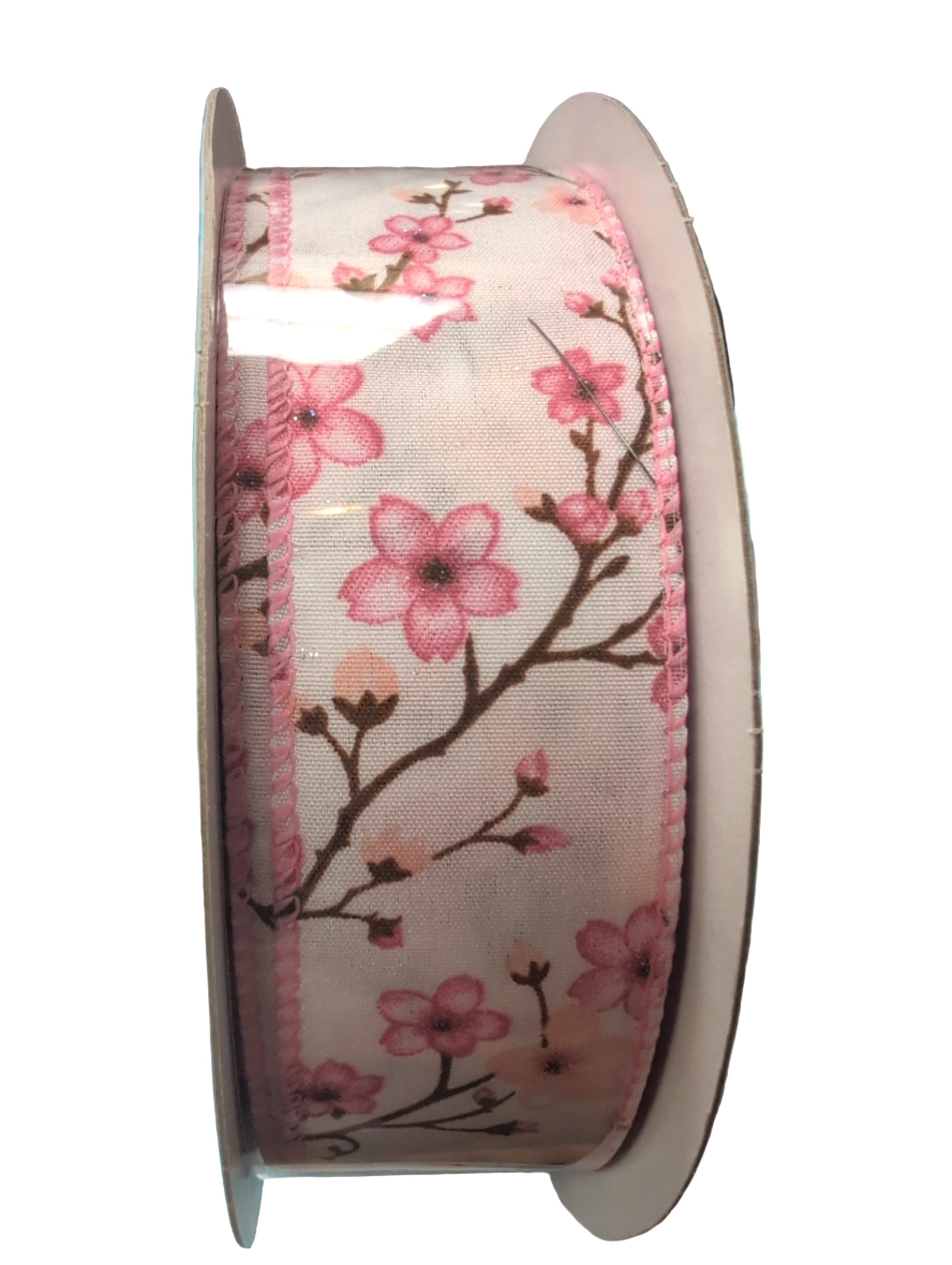 Spool of ribbon with pink floral design on a white background