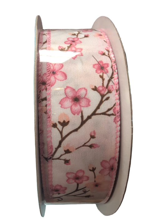 Spool of ribbon with pink floral design on a white background