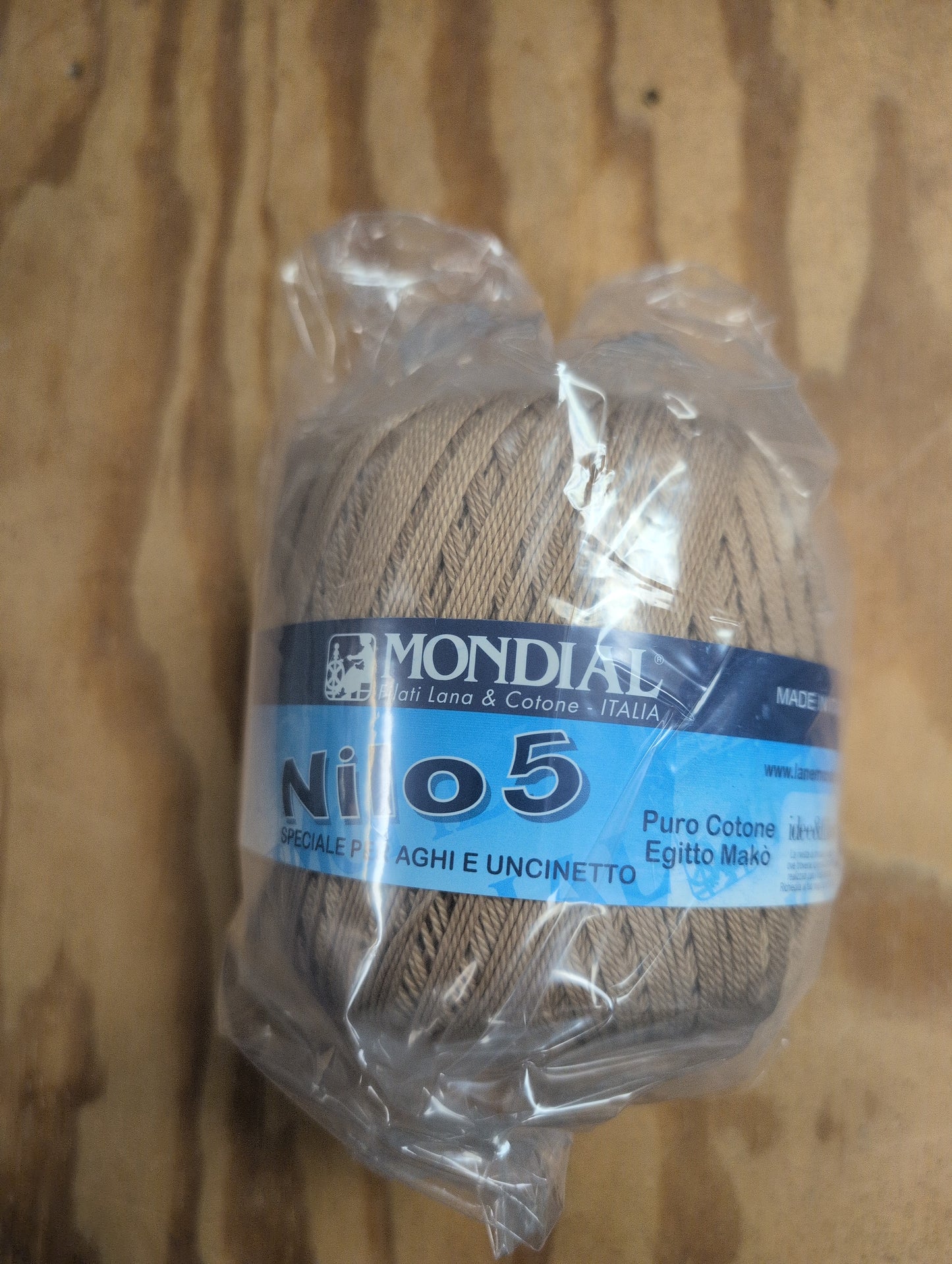 Ball of yarn with a blue label on a wooden surface