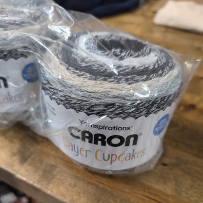 Packaged layer cake on a wooden surface with visible brand name.