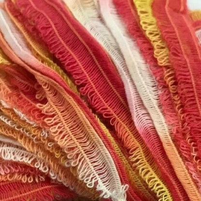 Close-up of colorful textured fabric with red, orange, and white patterns.