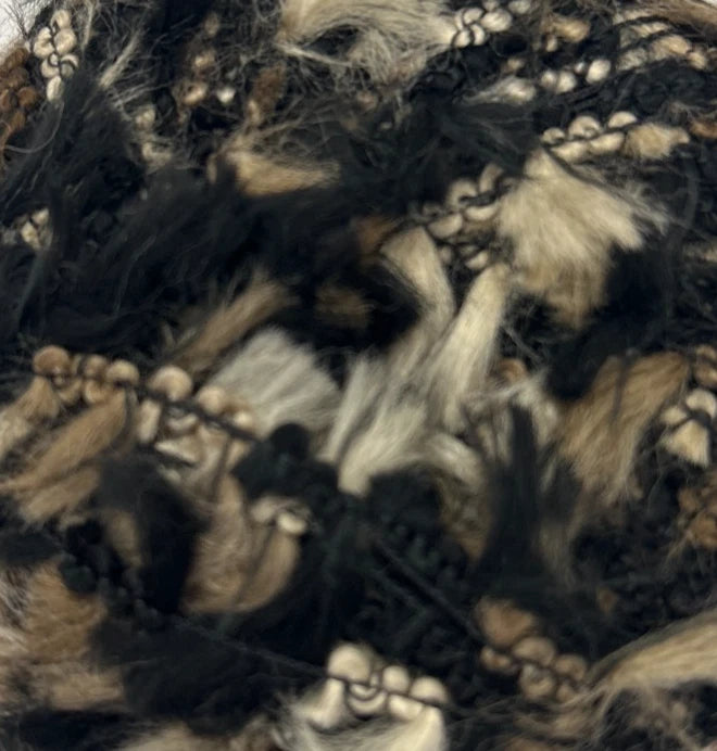 Close-up of a textured fabric with black, brown, and beige colors.