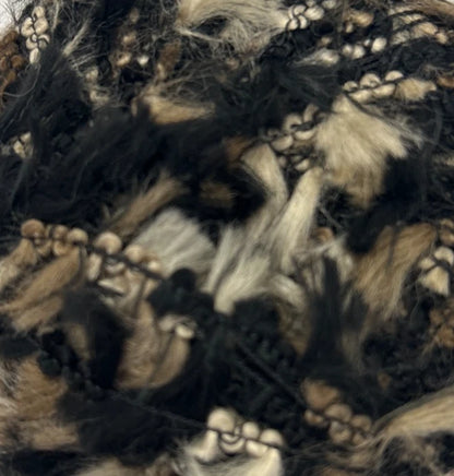 Close-up of a textured fabric with black, brown, and beige colors.