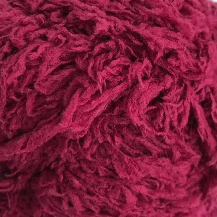 Close-up of a ball of red yarn on a white background