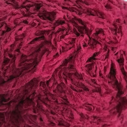 Close-up of a ball of red yarn on a white background