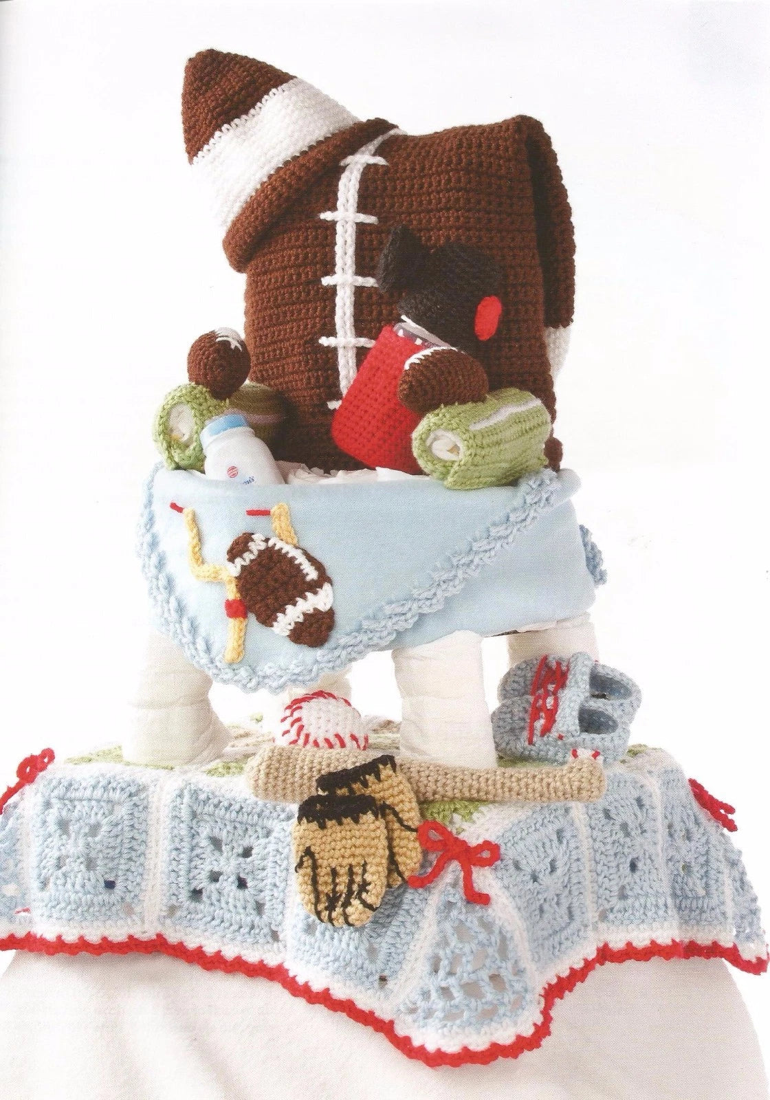 Crocheted teddy bear with sports-themed accessories on a white background