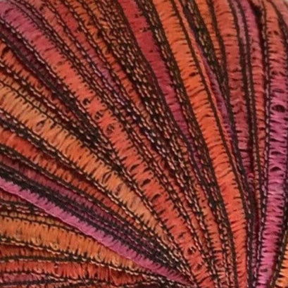 Close-up of multicolored yarn with red, orange, and purple hues.