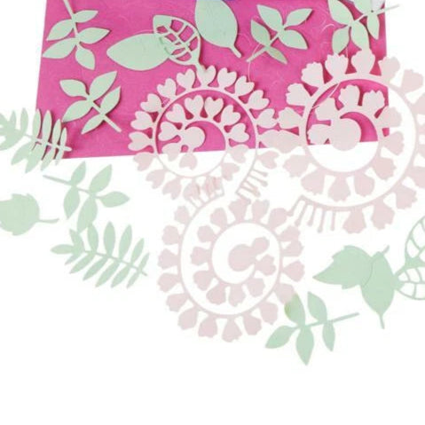 Decorative paper with floral cutouts on a pink background