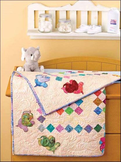 Baby quilt with colorful animal designs on a crib