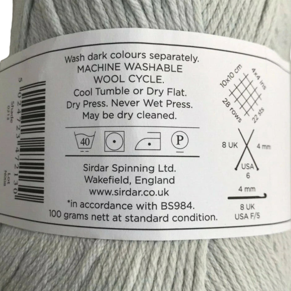 Yarn label with washing instructions and product details on a ball of gray yarn.
