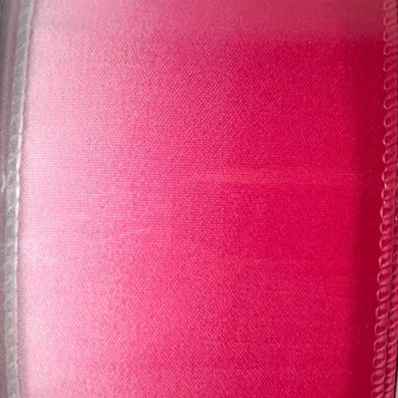 Spool of pink ribbon on a white background