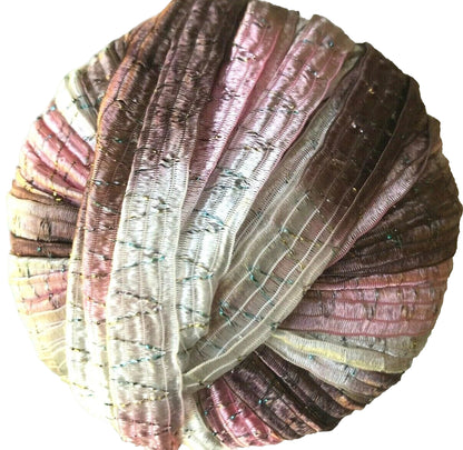 Multicolored yarn ball with a gradient of brown, pink, and beige on a white background