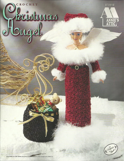 Crocheted Christmas angel doll with a sleigh and presents on a snowy background, featuring Annie's Attic branding.