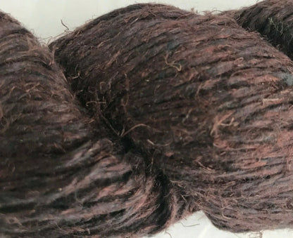 Close-up of dark brown yarn on a white background