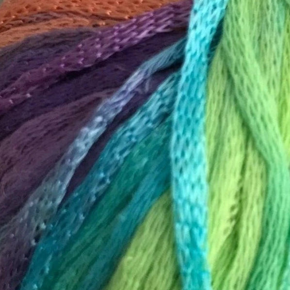 Close-up of colorful yarn strands in purple, blue, green, and orange.