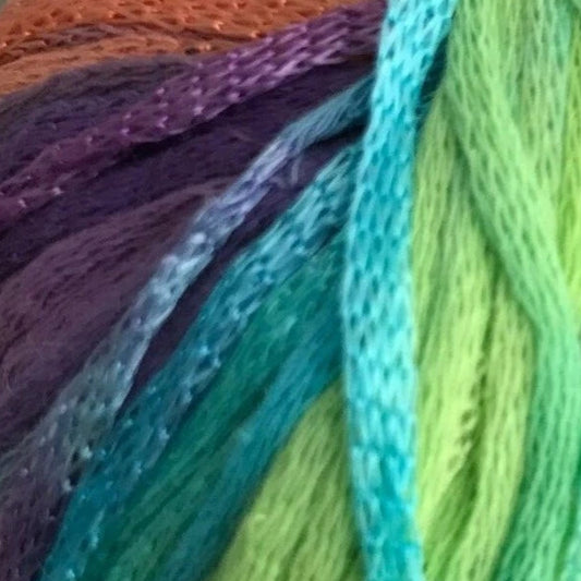 Close-up of colorful yarn strands in purple, blue, green, and orange.