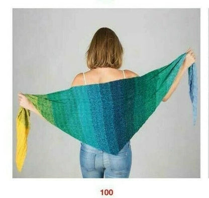 Woman holding a green and blue gradient shawl against a plain background