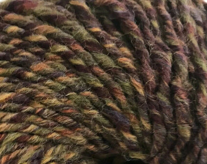 Close-up of a ball of multicolored yarn with earthy tones.